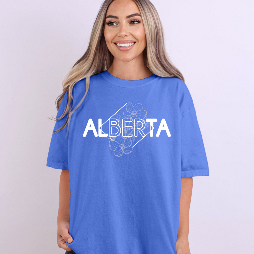 Woman wearing a blue t-shirt with 'Alberta' printed on it against a white background